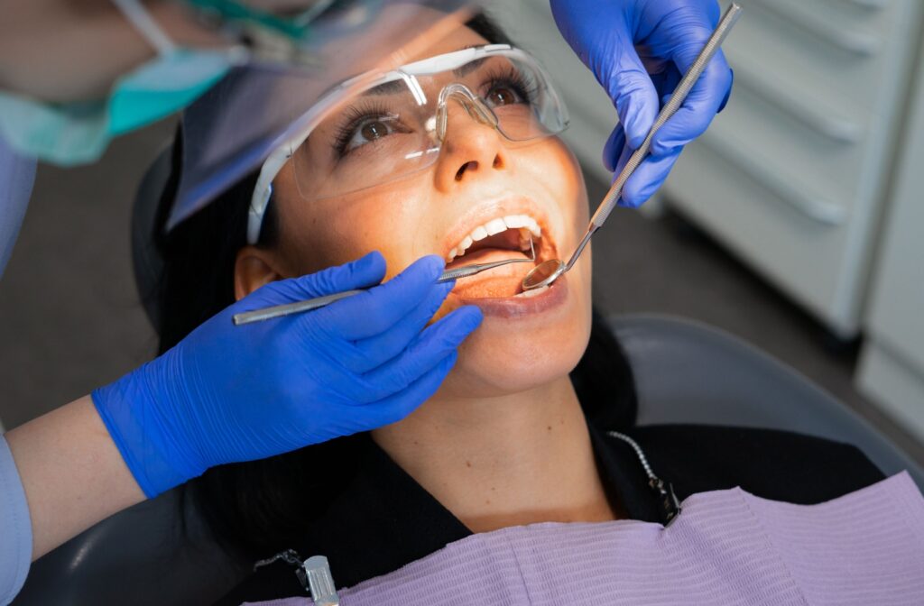 The dental hygienist examines their patient's teeth as part of the professional dental cleaning process.
