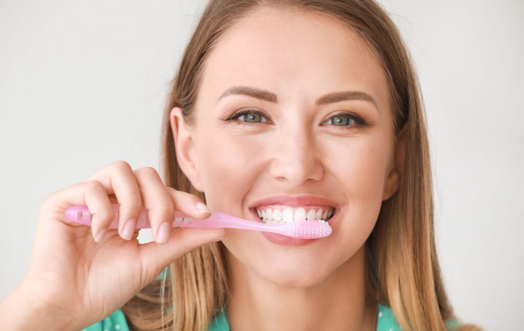 A person brushes their teeth at the end of the day to support their dental health.