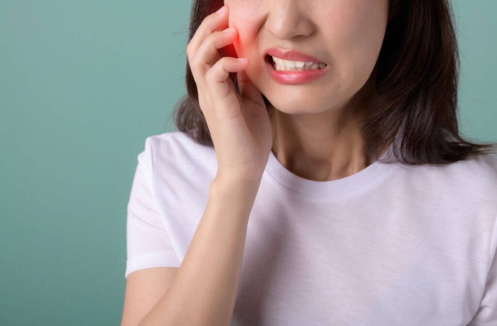 A person holding their jaw from pain caused by a cavity